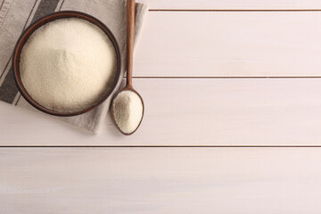 Uncooked organic semolina on white wooden table, flat lay. Space for text