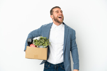 Young caucasian making a move while picking up a box full of things isolated on white background...