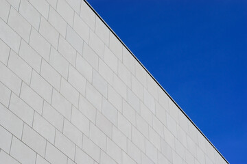 gray cement brick wall of corporate building facade on blue sky background