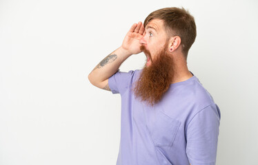 Young reddish caucasian man isolated on white background with surprise expression while looking side