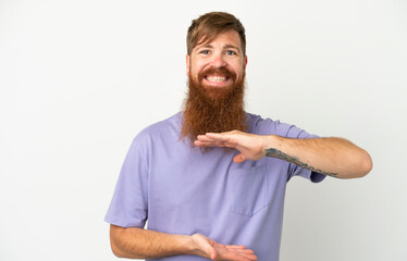 Young reddish caucasian man isolated on white background holding copyspace imaginary on the palm to insert an ad