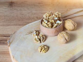 Fototapeta na wymiar Bowl with delicious walnuts on a wooden table