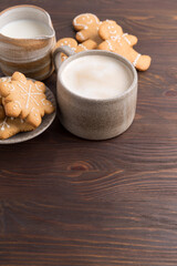 Coffee with milk and gingerbread cookies on wooden background. Winter hot drinks.
