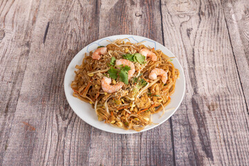 Pad thai, rice noodles, fish sauce, tamarind paste, red pepper, bean sprouts, shrimp, chicken with chopped peanuts and coriander, lemon wedge, banana flower, palm sugar and toasted chili pepper