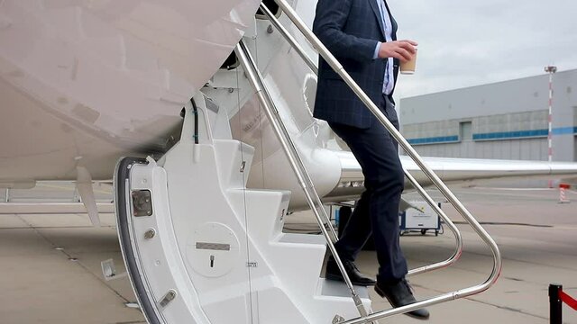 close up video of feet in expensive shoes coming out of a business jet, a man walking down the stairs of a business jet. High quality FullHD footage