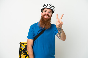 Young reddish caucasian man with thermal backpack isolate don white background smiling and showing victory sign