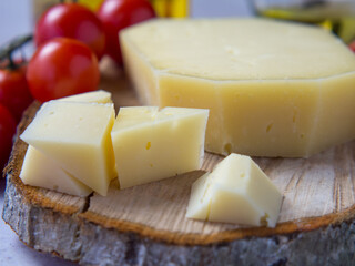 Homemade healthy food concept: cherry tomatoes, cheese slices and olive oil on light concrete background