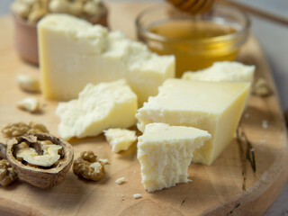 farm cheese served with honey and nuts on a light texture background. Copy space
