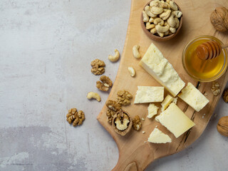 farm cheese served with honey and nuts on a light texture background. Copy space