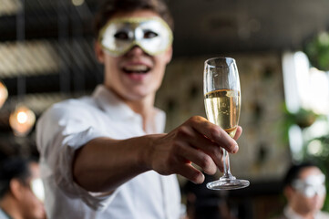Champagne glasses holding on hand's Young man in funny and happy Christmas and new year party atmosphere. Holiday celebrate and nightlife lifestyle concept