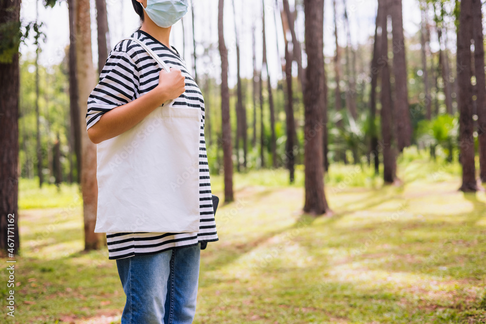 Wall mural hipster woman holding white cotton bag at park