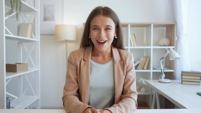 Excited woman. Online conference. Winner joy. Happy lady expressing euphoric emotion having video call in light room interior.