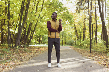 Fototapeta premium African american student walking in the park in autumn season