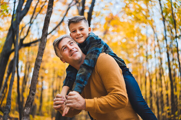 Father and daughter having fun in the autumn colorful forest