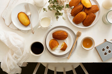 Table top of breakfast table and chair. Madeleine cakes, french pastry.