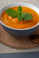 Pumpkin soup in a gray plate on the table
