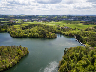 Fototapeta premium Aerial view of the Neyetalsperre (Neye Dam) in the Bergisches Land with a view of Wipperfuerth in the background.