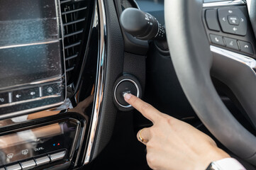 Naklejka premium Finger pushing on engine start botton in modern car