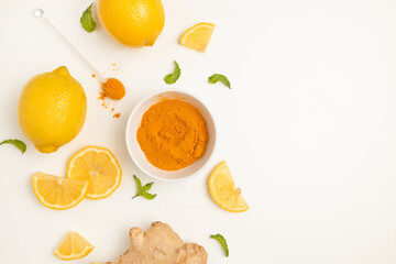 Fresh turmeric, ginger and citrus juice ingredients on a white table, top view. Natural vitamin drink that protects health from viruses.