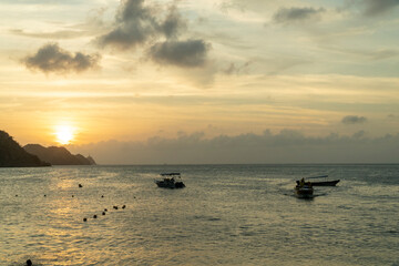 Nature landscape with colorful sunset and boats in the sea. Santa Marta, Magdalena, Colombia.