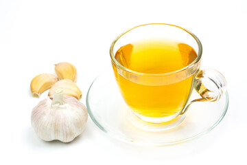 Garlic tea in transparent glass with garlic isolated on white background.