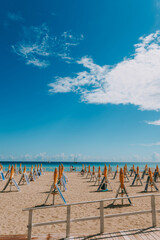 Summer season has ended, closed parasols and sunbeds closed on a sunny sandy beach