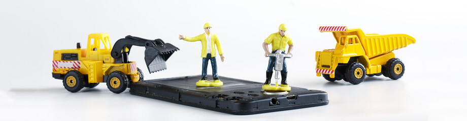 Toy man workers repair or dispose of a mobile phone or smartphone using a jackhammer, dump truck...