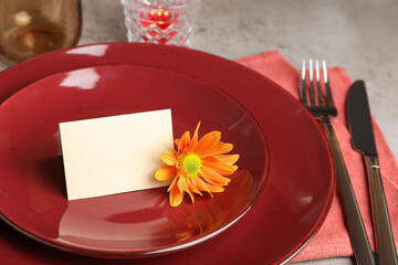 Beautiful autumn place setting with blank card and decor on grey table, closeup