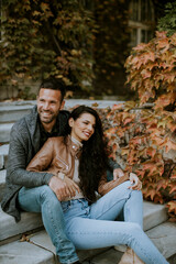 Young couple sitting on stairs in autumn park