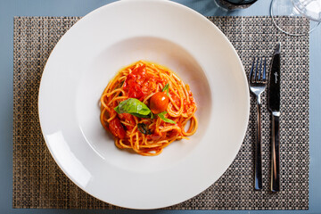Spaghetti con sugo di pomodoro e basilico fresco serviti in un ristorante come primo piatto