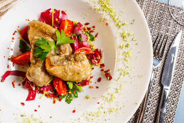 Piatto di un ristorante con baccalà fritto, pomodori, prezzemolo e pomodori secchi sbriciolati