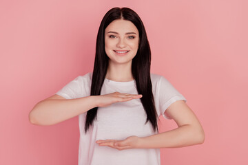 Photo of cheerful advertiser lady hands show measure size empty space invisible object isolated on pink color background