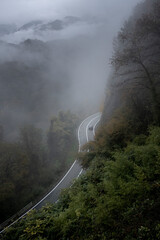 Mountain road in foggy and rainy autumn day. Traveling by car in bad weather. 