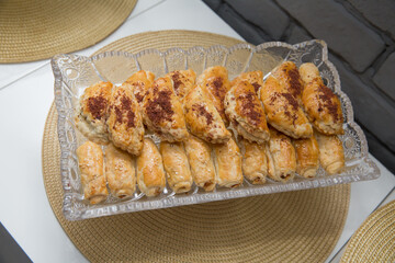 Baked pies in the oven. On a white plate and a peach color background . Pies with meat, cabbage or any filling.