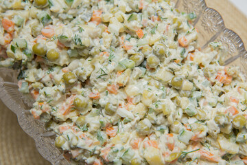 Mayonnaise salad. Food background - salad olivier close-up. Green peas, cucumber, potatoes, sausage, mayonnaise . Azerbaijani capital salad.On the plate capital salad.