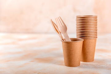 Eco-friendly disposable paper tableware. Paper cup, wooden forks, recycling or green concept. copy space
