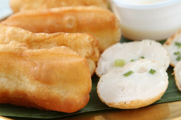 Fried patongko and Kanom krok or coconut-rice pancake on golden plate. - obrazy, fototapety, plakaty