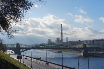 Fototapeta premium Sun rays during the cloudy day in autumn. View from the river bank in the center of Moscow, Russia