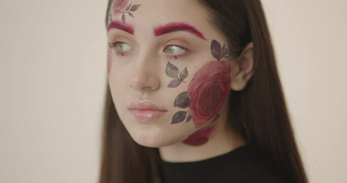 close-up of a young beautiful girl whose face is beautifully painted with flowers