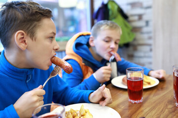 Two children eating sausages