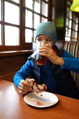 Boy drinking kvass with bun