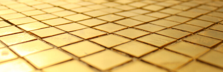 Golden mosaic surface, gold tiles background, selective focus photography.