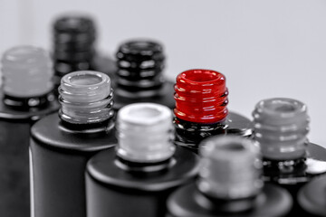 Bottles with gel varnishes for manicure and pedicure close-up. Black and white photo with a red accent. Materials for a beauty salon. Horizontal photo.