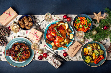 Christmas evening table top view with festive food and sparkling wine glasses, Xmas dinner with assorted delicious meals, wrapped presents and fir tree flat lay 
