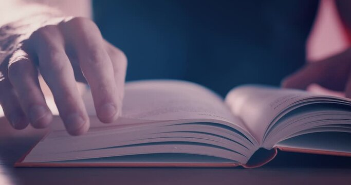 Reading and turning the pages of a hardback book close up