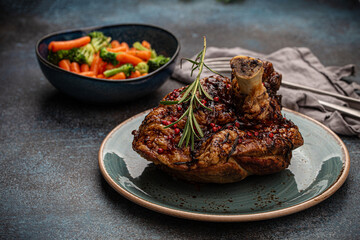 Delicious roasted ham or pork knuckle with glazed brown crispy skin, red pepper berries and...