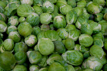 Brukselka przygotowania do sprzedaży na targu / Brussels sprouts preparing for sale at a market - obrazy, fototapety, plakaty