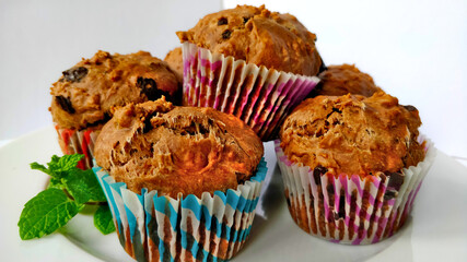 Detail view on delicious sweet soft muffin with chocolate decorated with freshly picked mint.