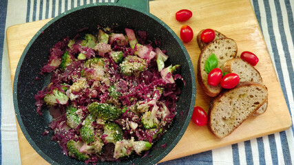 Detail of vegan cabbage dish broccoli, small tomatoes, bread and hemp seeds.