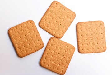 four square shaped biscuit on white background, top view, selective focus